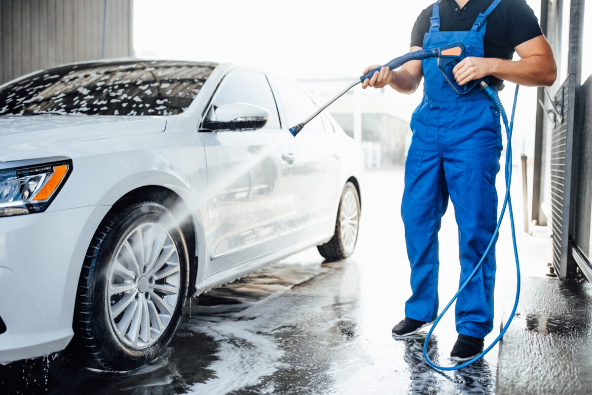Pressure washing machine being used to clean a car